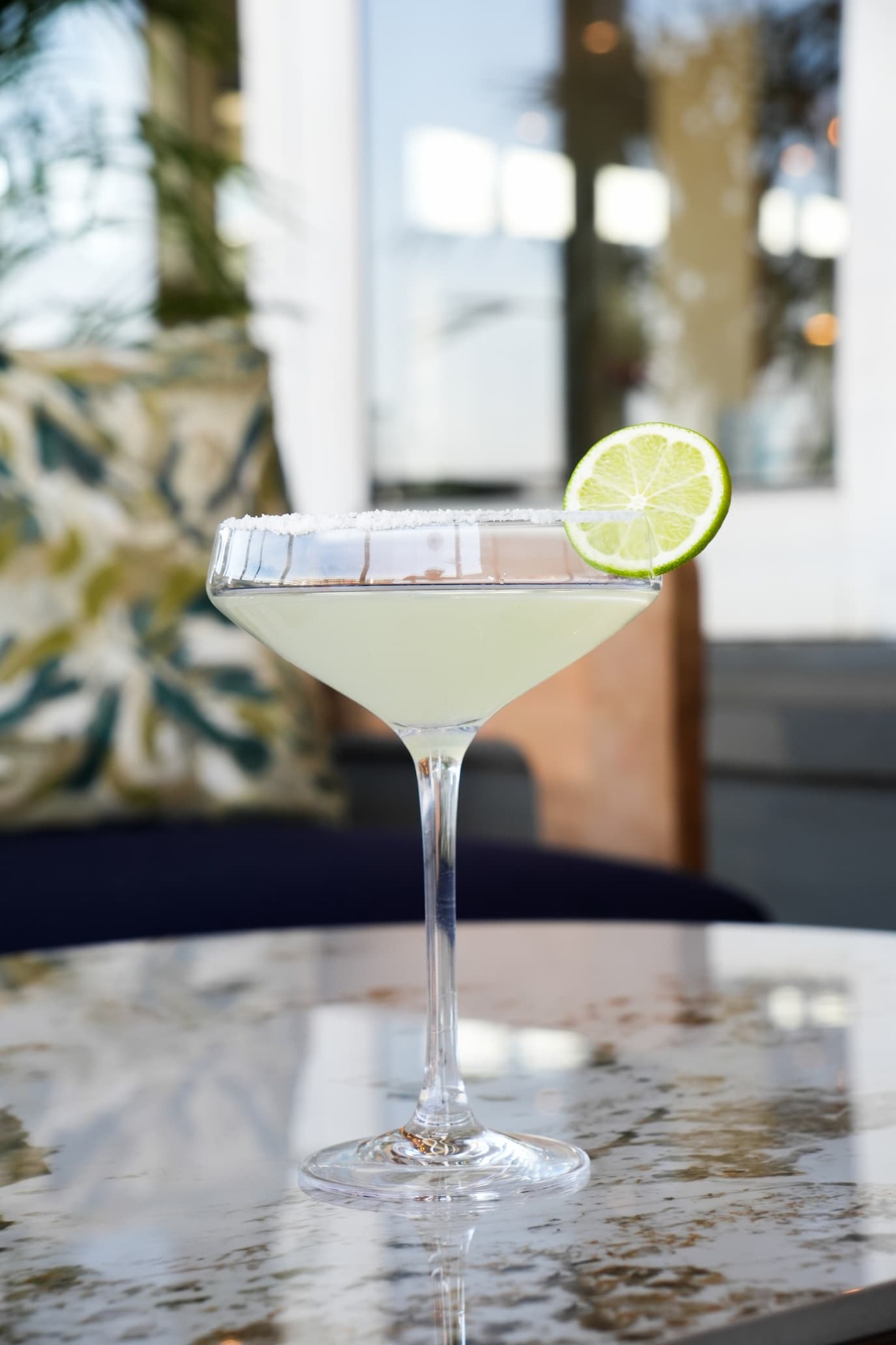 Clear cocktail with a lime garnish